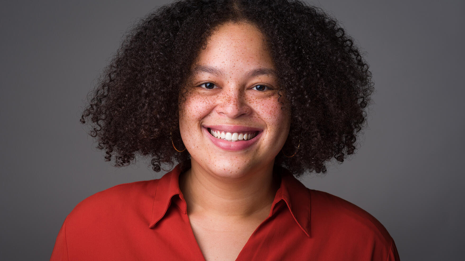 Headshot for young professional black woman smiling afro freckles red blouse by Tampa photographer Sidney Oster