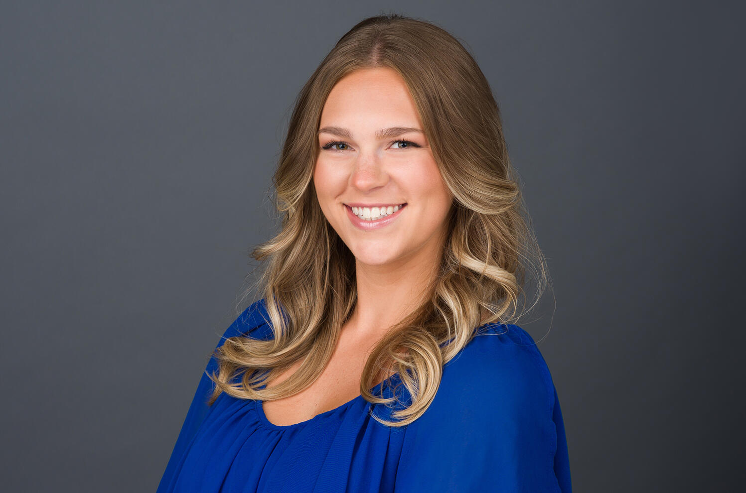 Corporate headshot of female professional with dark background by Tampa photographer Sidney Oster