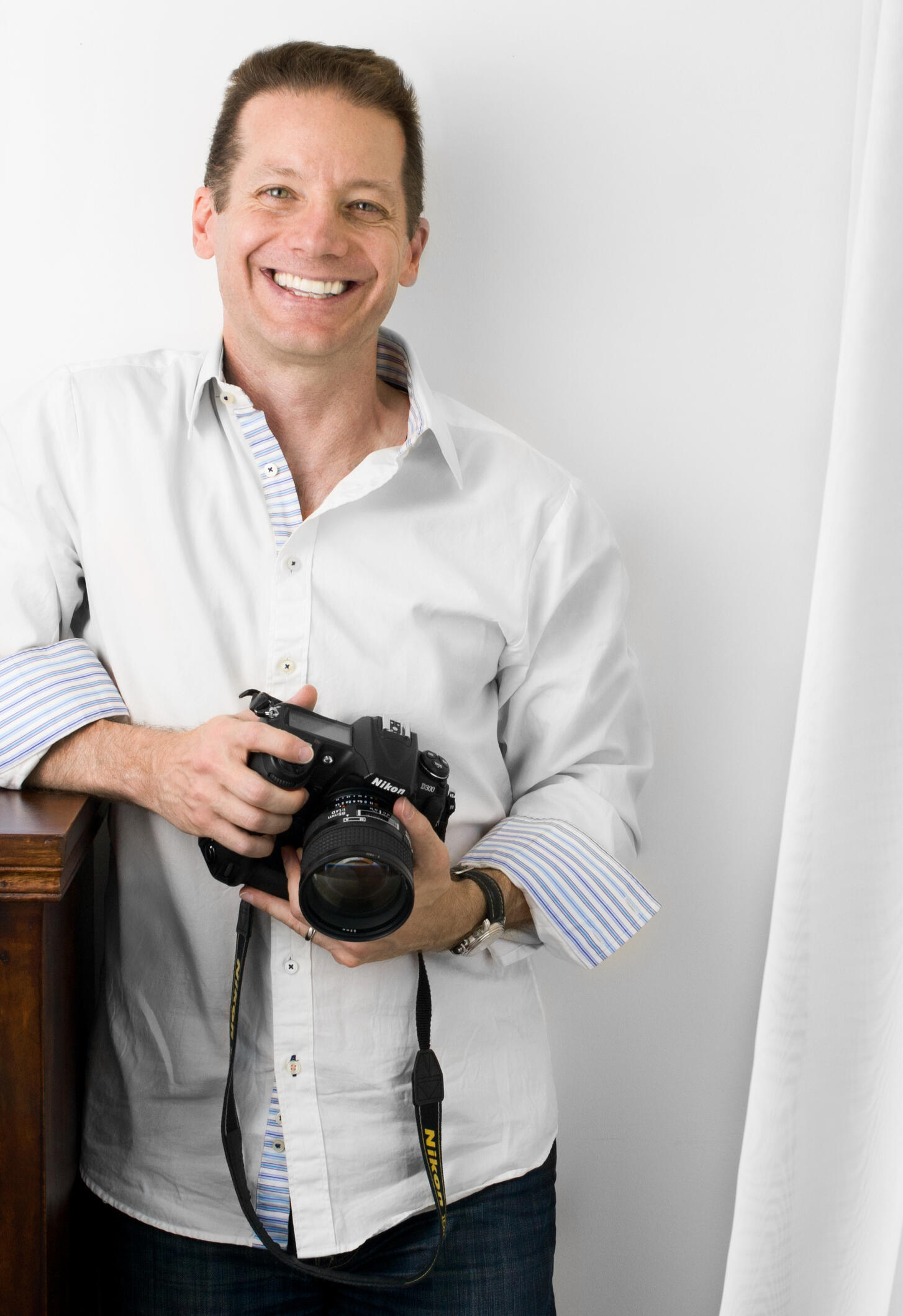Behind the Scenes ( BTS) at the Slide Insurance corporate holiday party Portrait of Sidney Oster holding a camera and the Tampa Bay Buccaneers flag on the field at Raymond James Stadium. In partnership with SpotMyPhotos.