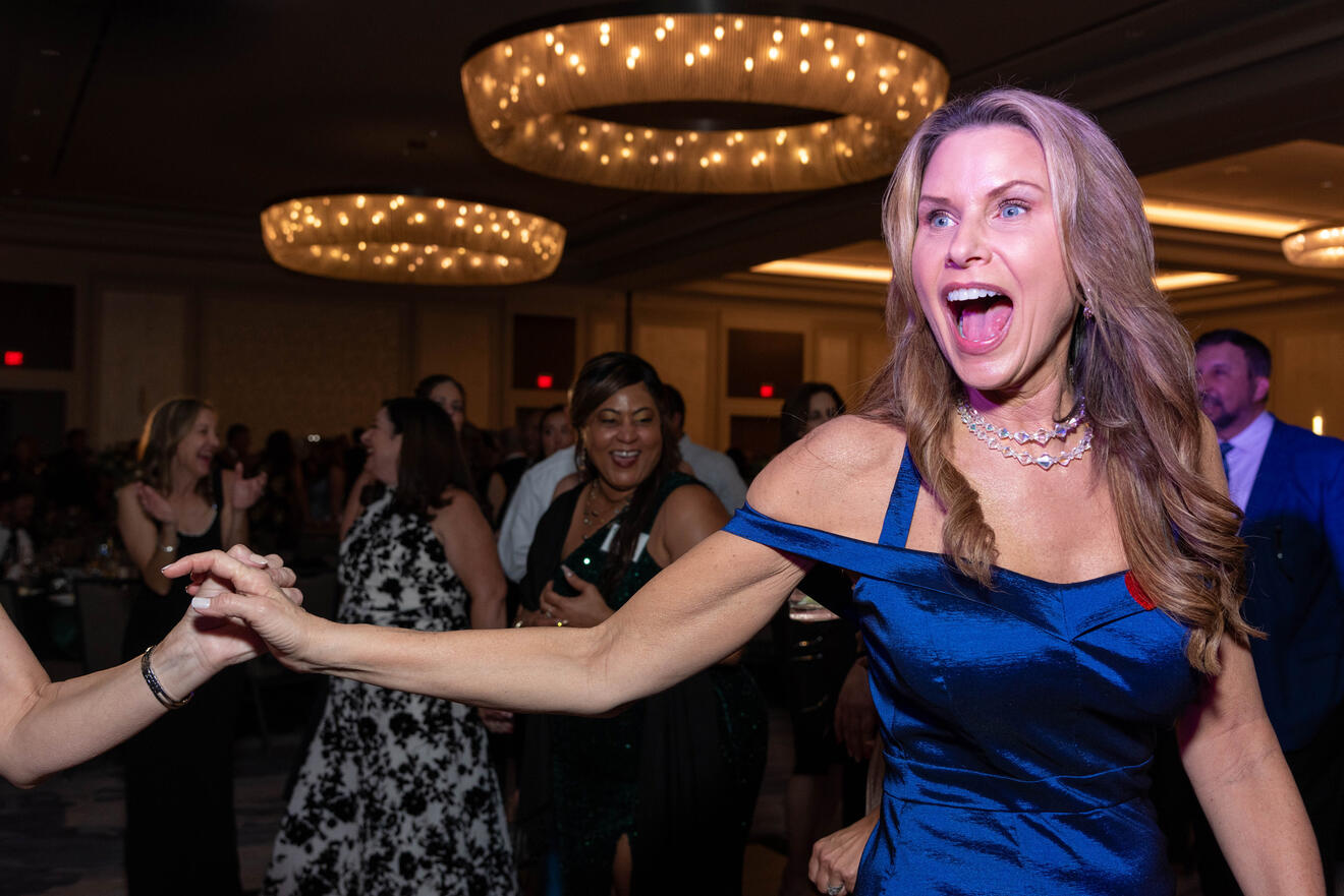 Tampa corporate event photography at nonprofit fundraising gala showing guest celebrating on dance floor by Sidney Oster Photography